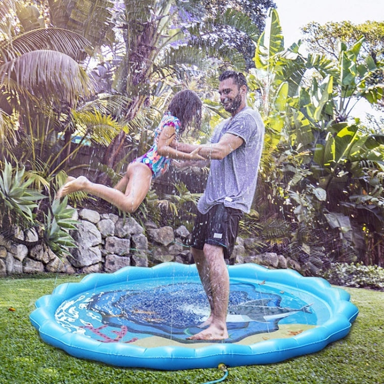 Family playing on blue sprinkler play mat with water spray outdoors