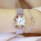 Ladies square dial wristwatch on wrist with silver metal mesh strap and light dial