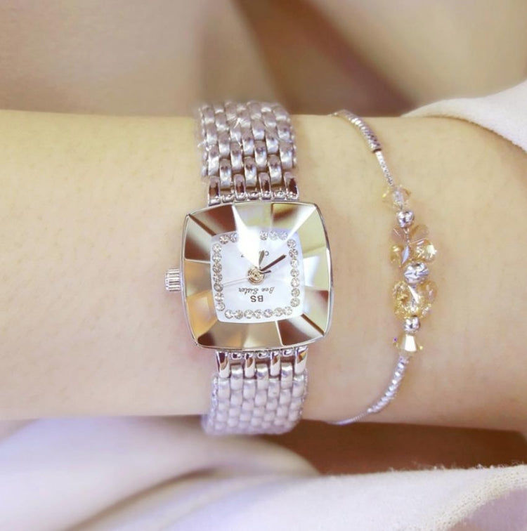 Ladies square dial wristwatch on wrist with silver metal mesh strap and light dial