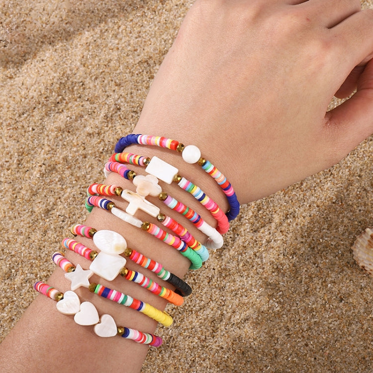 Stacked multicolor beaded bracelets with white star and heart charms on wrist