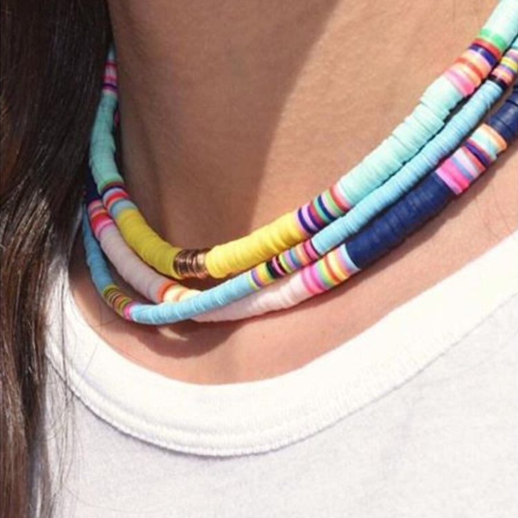 Layered rainbow heishi beaded necklace with gold bead clasp on neck