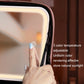 Pink makeup bag LED lamp panel close-up with hand pressing the light control button