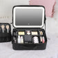 Black makeup bag with built-in LED lamp, open organizer holding makeup essentials
