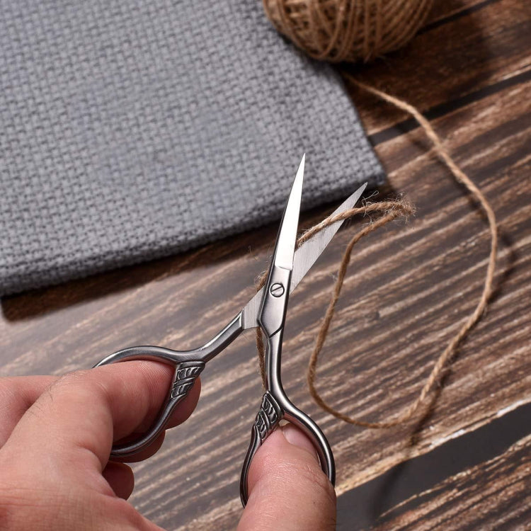Hand using beard scissors for trimming, pointed blades and finger loops, silver metal