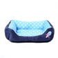 Square pet bed with blue polka dot cushion and dark navy sides, small bow detail
