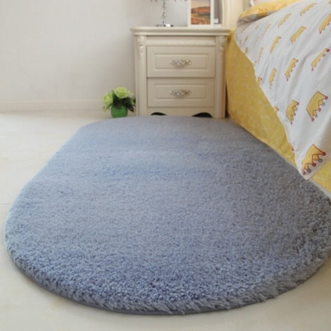 Light blue-gray oval plush pet bed pad with soft shag pile and flat surface