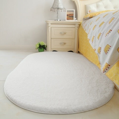 White plush pet bed pad with shag texture and rounded oval cushion