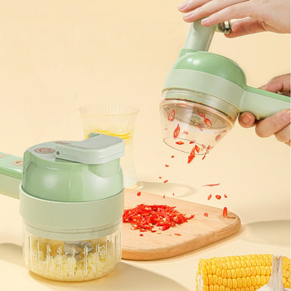 Green handheld electric garlic chopper with transparent bowl and slicing blade