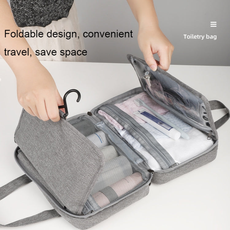 Gray foldable toiletry bag open with transparent pockets and zip compartments on strap