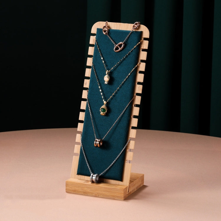 Bamboo necklace stand with blue velvet backing, holding layered necklaces