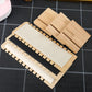 Stacked bamboo necklace stands with beige, cream, and black fabric panels