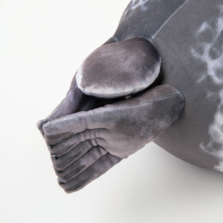 Gray seal plush pillow showing curled flipper and stitched seam