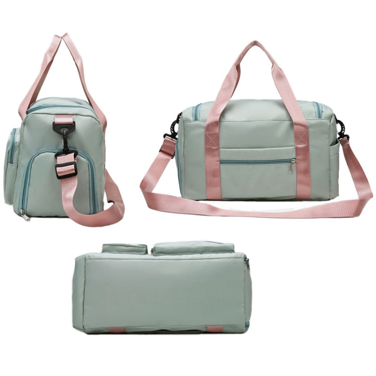 Light green waterproof travel duffel bag with pink straps, front pocket, and zip top