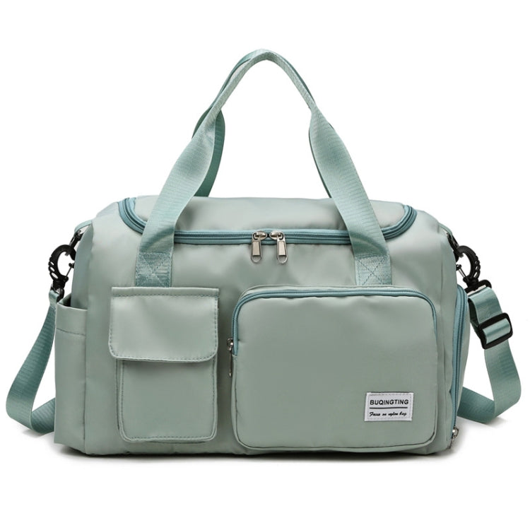 Light teal waterproof travel duffel bag with front pockets, zip top, and crossbody strap