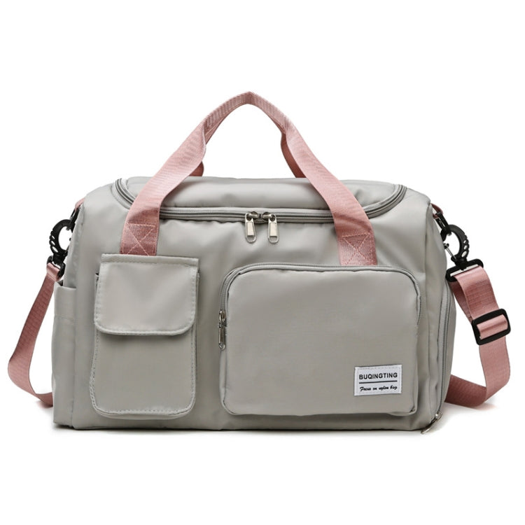 Light gray waterproof travel duffel bag with front pockets and pink adjustable shoulder strap