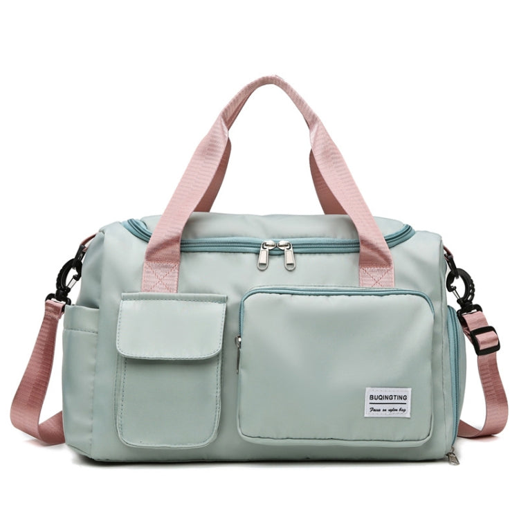 Mint green waterproof travel duffel bag with front pockets and pink shoulder straps