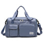 Blue-gray waterproof travel duffel bag with front pockets, top zipper, and shoulder strap