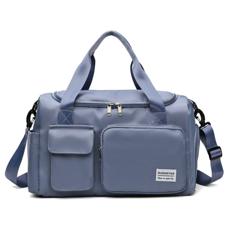 Blue-gray waterproof travel duffel bag with front pockets, top zipper, and shoulder strap