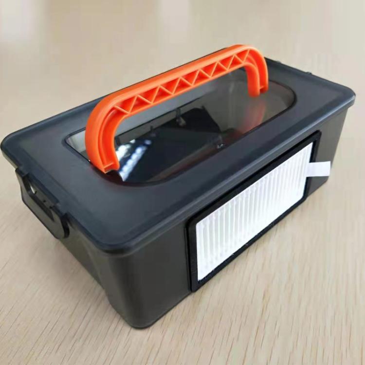 Robot vacuum filter compartment with white HEPA filter and orange pull handle