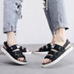 Men’s black sandals with thick sole and adjustable straps worn with rolled jeans