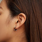 Cat-ear hoop earrings worn on ear, dark silver metal with pink inner accents
