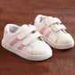 Kids white sneakers with pink side stripes and double hook-and-loop straps