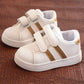 Kids white sneakers with gold side stripes and two hook-and-loop straps