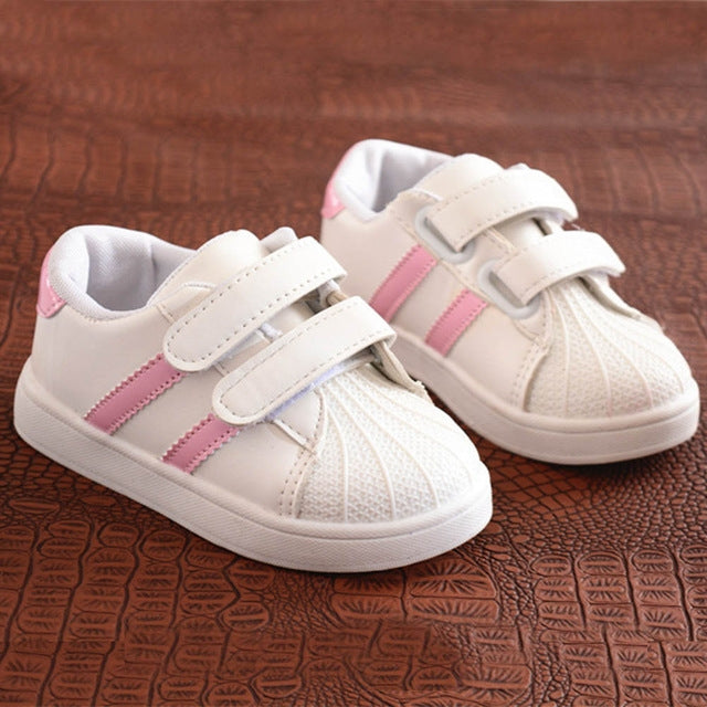 Children's white sneakers with pink side stripes and two-strap Velcro closures