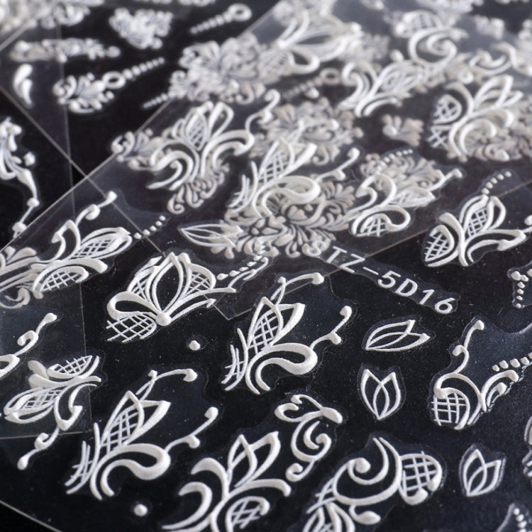 3D carved nail art sticker close-up with white leaf, bow, and scroll motifs on black