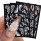 3D carved nail art sticker sheet with white ornate floral swirls; pearls on sample nails