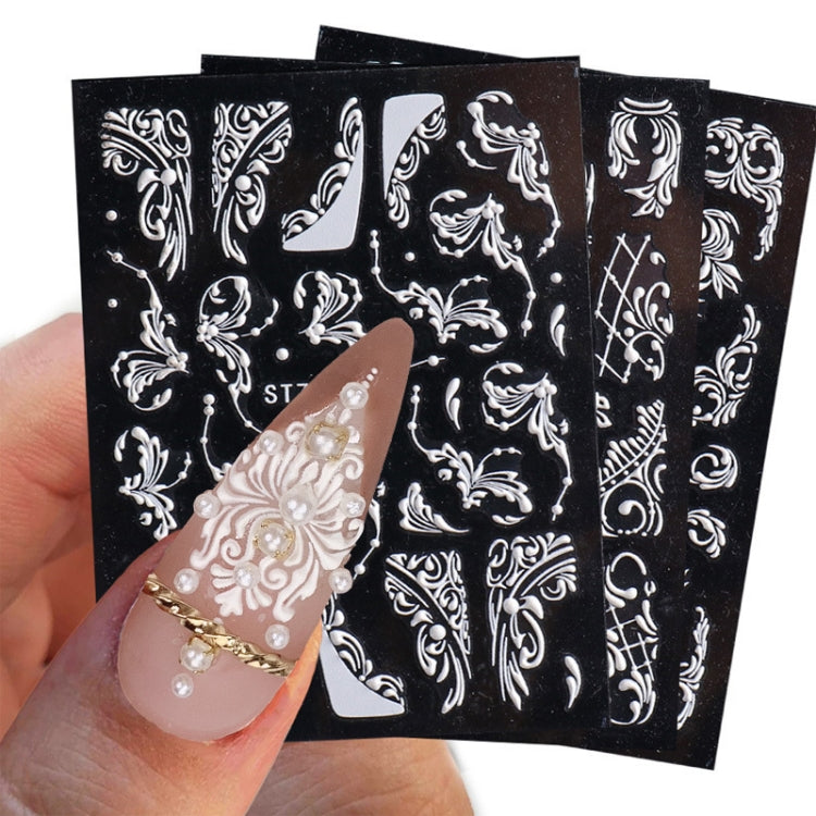 3D carved nail art sticker sheet with white ornate floral swirls; pearls on sample nails