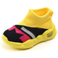 Kids yellow knit ankle sneakers with black side panels and pink/white pattern, grippy sole