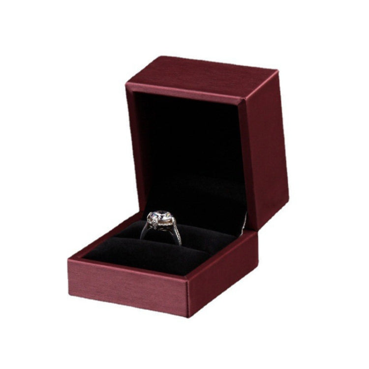 Wine red PU leather ring jewelry box with open lid and silver ring on black insert