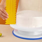 Yellow plastic double-sided sawtooth cake flattener scraper, used on cake