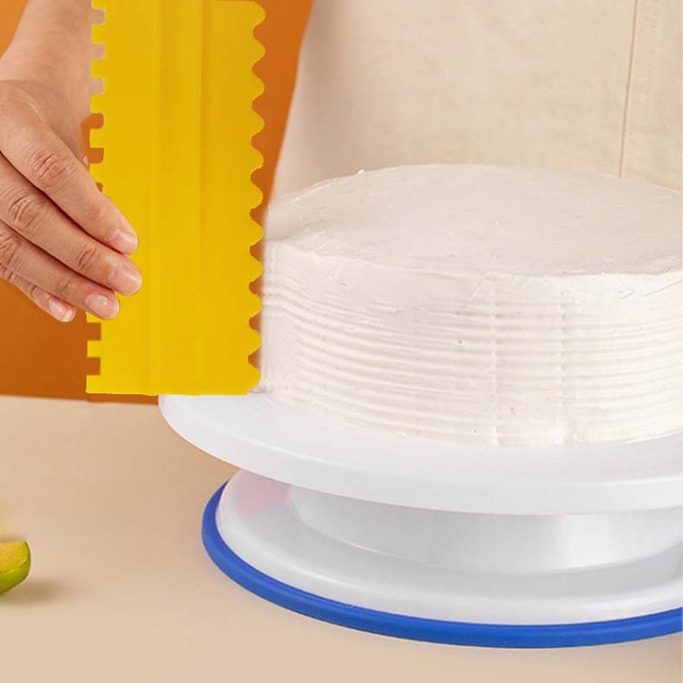 Yellow plastic double-sided sawtooth cake flattener scraper, used on cake