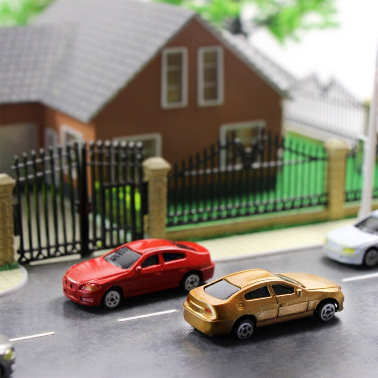 Small model cars parked on a street scene, red and gold vehicles in front