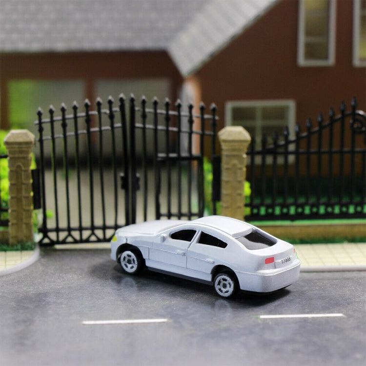 White small model car parked on a driveway scene with fence backdrop