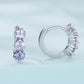 Pair of silver hoop earrings with three purple zirconia stones