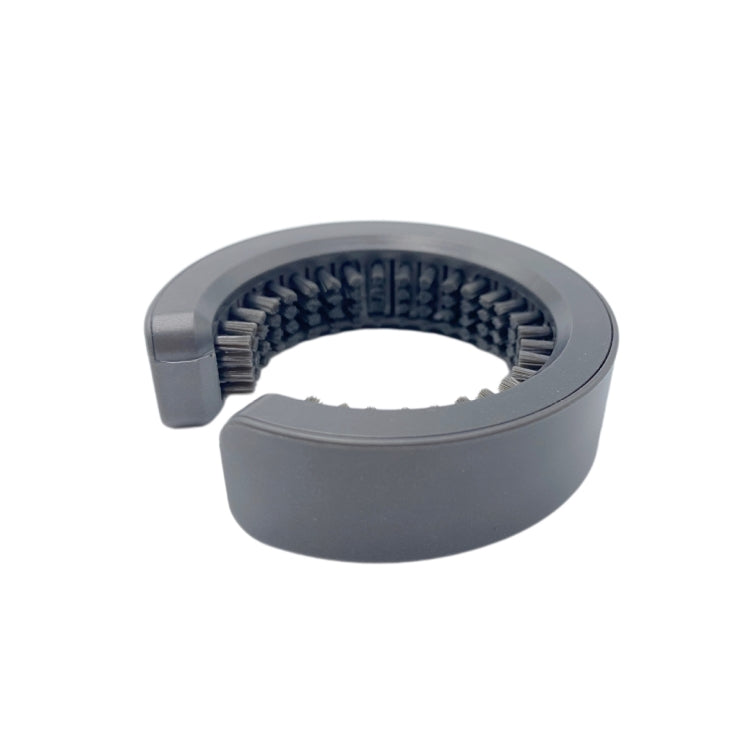 Round gray cleaning comb with black bristles in a curved cylinder shape