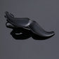 Black leather-look tie clip with curved top bar and spring clasp, glossy finish.
