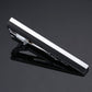 Black tie clip with wide white center bar and silver metal clasp, glossy finish.