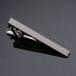 Black-and-silver tie clip with textured metal bar and hinged clasp