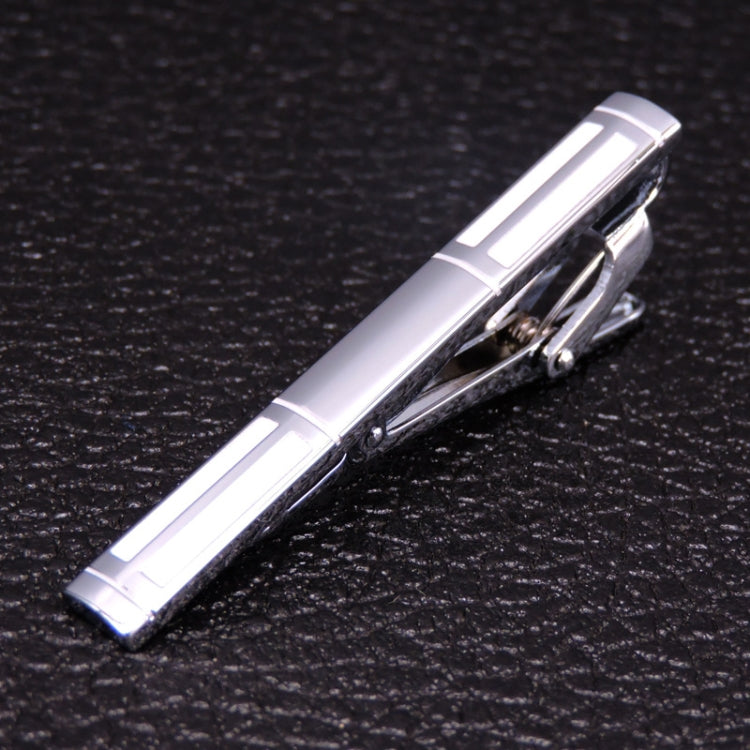 Silver tie clip with raised geometric lines and hinged clasp