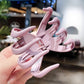 Pink frosted hair grab claw clip held in a hand