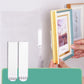 Two white hook-and-loop strips holding a small framed photo on wall
