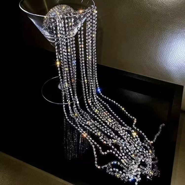 Sparkly rhinestone chain hair band draping over hair with long fringe strands.