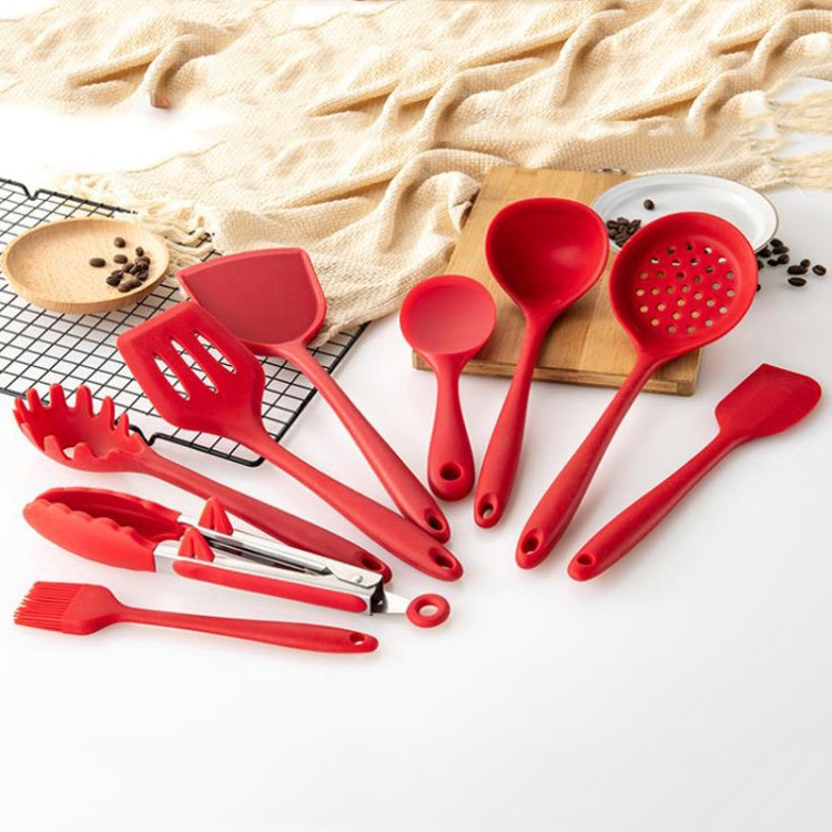 Red silicone cooking utensils set with multiple spatulas and spoons, hanging loops.