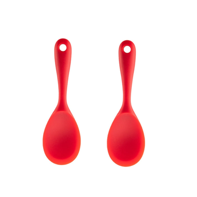 Red silicone rice spoon with rounded scoop head and loop handle.