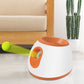 White and orange tennis ball launcher with tennis ball loaded on the top opening.
