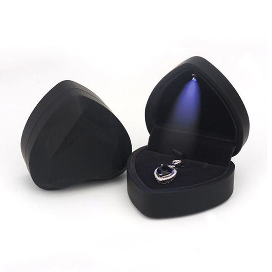Heart-shaped LED jewelry storage box, black with open lid and ring on velvet cushion